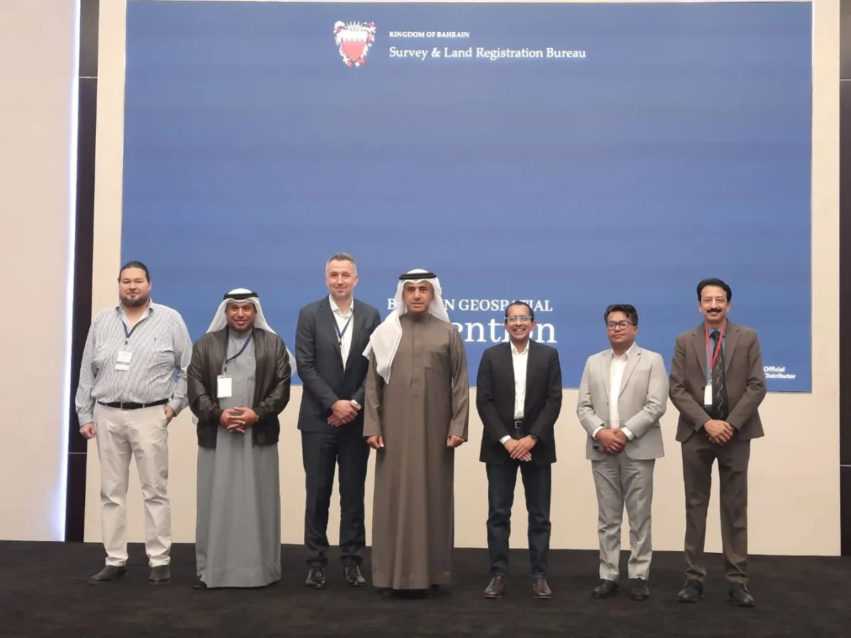 Group photo at the Bahrain Geospatial Convention in front of the Survey and Land Registration Bureau backdrop